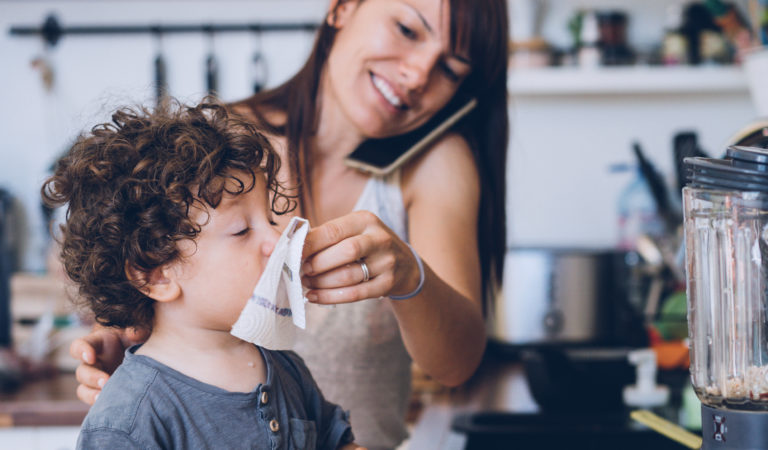 Mother helping son to blow his nose